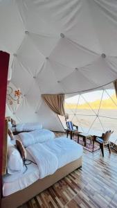 a bedroom with three beds in a tent at Wadi Rum Maracanã camp in Wadi Rum