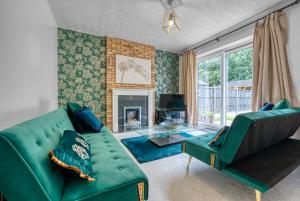 a living room with a green couch and a fireplace at CAPRI 13 SA - 3 bed House, Close to Loughborough University & M1 motorway, Free Wifi, Big garden, Ample parking- Ask for contractor rates! in Loughborough