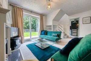 uma sala de estar com um sofá verde e uma televisão em CAPRI 13 SA - 3 bed House, Close to Loughborough University & M1 motorway, Free Wifi, Big garden, Ample parking- Ask for contractor rates! em Loughborough