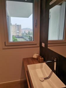 lavabo blanco en un baño con ventana en B&B Portello Le Terrazze 1 en Milán