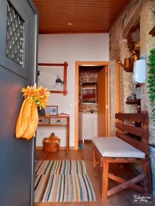 uma sala de estar com um banco e uma mesa em O Cantinho da Ana em Sortelha