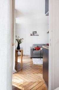 een woonkamer met een bank en een houten vloer bij CUTE & COSY 1BDR HOTEL DE VILLE / LE MARAIS in Parijs