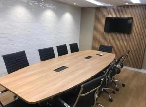 a conference room with a large wooden table and chairs at Flat aconchegante in Goiânia