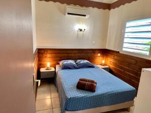 ein Schlafzimmer mit einem blauen Bett und zwei Nachttischen in der Unterkunft Baz créole in Deshaies