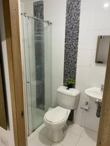 a bathroom with a toilet and a glass shower at La Morada del Sur in Floridablanca