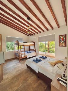a bedroom with two bunk beds and a television at Finca Hotel California Doradal in Doradal