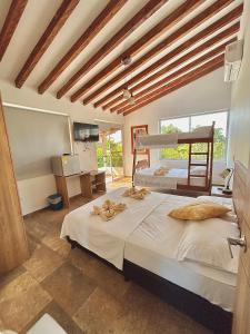 a bedroom with two beds and a large window at Finca Hotel California Doradal in Doradal