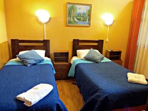 two beds in a hotel room with towels on them at Hostal Remember in Temuco