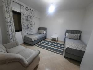 uma sala de estar com duas camas e um sofá em magnifique appartement em Tânger