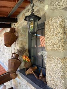 una finestra con vasi di fiori e una lampada su un muro di O Cantinho da Ana a Sortelha