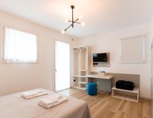 a white bedroom with a bed and a desk at TommyHouse in Borso del Grappa