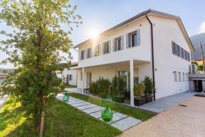 a white house with green vases in the yard at TommyHouse in Borso del Grappa