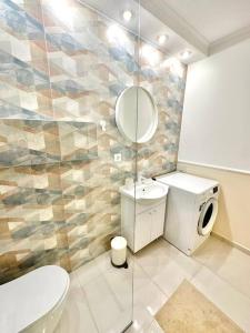 uma casa de banho com um WC, um lavatório e um espelho. em Serendipity I Sala Palatului em Bucareste
