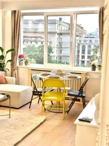 uma sala de estar com uma mesa e cadeiras e uma janela em Serendipity I Sala Palatului em Bucareste