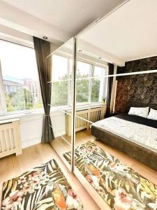 um quarto com uma cama e uma grande janela em Serendipity I Sala Palatului em Bucareste