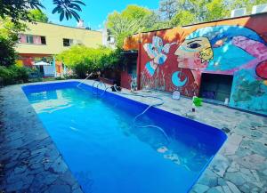 a swimming pool with a painting on the side of a building at Tu Hostel Tucuman in San Miguel de Tucumán