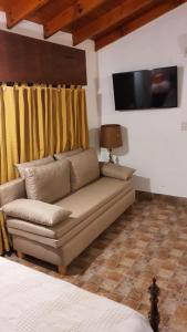 uma sala de estar com um sofá e uma televisão em Casa Quinta La Gualeya em Gualeguay