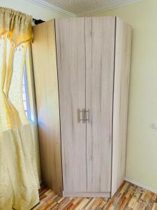 um armário de madeira num quarto com uma janela em Departamento amoblado calama em Calama