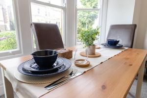 a wooden table with black cups and plates on it at April Disc - Long Stay - Contractors in Bristol