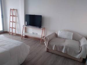 a living room with a couch and a flat screen tv at Northbeach, Pinamar in Costa Esmeralda