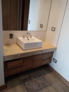 a bathroom with a sink and a mirror at Northbeach, Pinamar in Costa Esmeralda