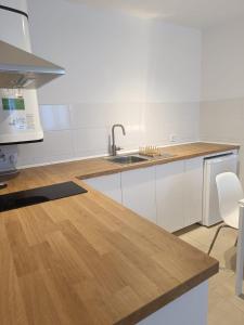 a kitchen with a sink and a wooden counter top at SHERRY SUÍTES III apartamentos in Jerez de la Frontera