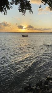 un barco en medio del agua al atardecer en Pousada Norage, en Cacha Pregos