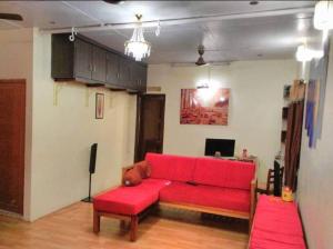 sala de estar con sofá rojo y escritorio en Imperial Heritage Home, en Port Blair