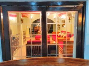 a glass door with red chairs in a room at Imperial Heritage Home in Port Blair