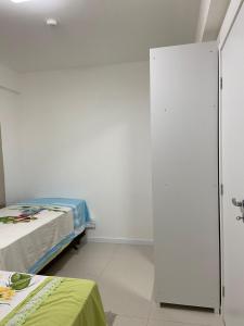瓜拉久巴的住宿－Apartamento em Guarajuba - Condomínio Paraíso dos Coqueiro，一间医院间,配有两张床和白色的墙壁