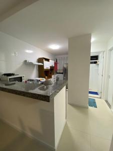 uma cozinha com bancada num quarto em Apartamento em Guarajuba - Condomínio Paraíso dos Coqueiro em Guarajuba