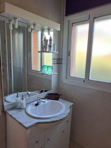 a bathroom with a sink and a mirror and a window at Villa LLoret Blau in Lloret de Mar