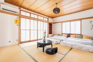 東京にあるComfy Home Aotoのテーブルと窓のある部屋にベッドが2つある