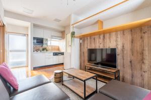 東京にあるComfy Home Aotoのソファとテーブルとテレビのあるリビングルーム