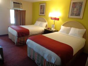 a hotel room with two beds and a window at Economy Inn Express Warren in Warren