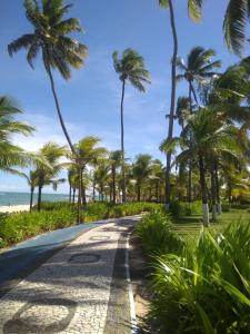 una carretera bordeada de palmeras en la playa en Apartamento em Guarajuba - Condomínio Paraíso dos Coqueiro, en Guarajuba