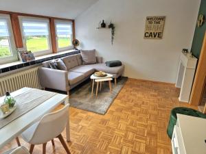 a living room with a couch and a table at Gemütliche Wohnung direkt am Küstenkanal! in Wardenburg