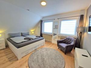 ein großes Schlafzimmer mit einem Bett und einem Stuhl in der Unterkunft Gemütliche Wohnung direkt am Küstenkanal! in Wardenburg