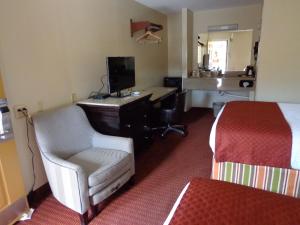 a hotel room with a bed and a desk and a chair at Economy Inn Express Warren in Warren