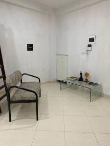 een kamer met een stoel en een glazen tafel bij Apartment studio fotografico in Huancayo