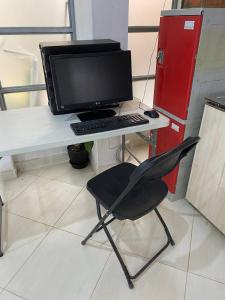 a desk with a computer monitor and a chair at Apartment studio fotografico in Huancayo