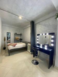 een slaapkamer met een bureau en een bed met een spiegel bij Apartment studio fotografico in Huancayo