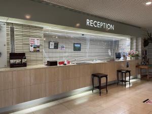 a reception counter in a store with two stools at Kitaguni Grand Hotel in Rishirifuji