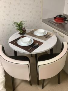 une table à manger avec deux chaises ainsi qu'une table et des chaises blanches dans l'établissement 遊泊天王寺YupaStay, à Osaka