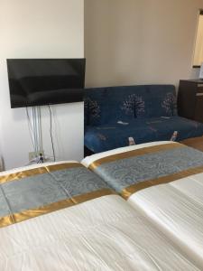 une chambre avec deux lits et un canapé dans l'établissement 遊泊天王寺YupaStay, à Osaka