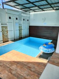 a large swimming pool in a building with a blue floor at Villa Omakost3probolinggo in Probolinggo