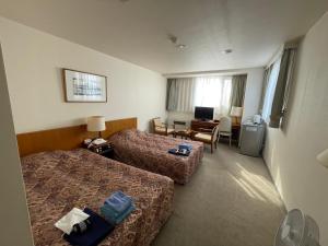 利尻富士町にある北国グランドホテルのベッド2台とデスクが備わるホテルルームです。