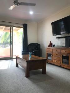 a living room with a coffee table and a tv at Murchison View Apartments in Kalbarri