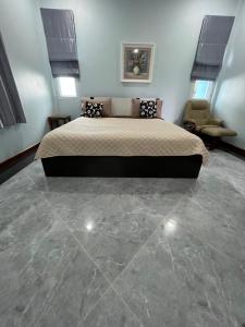 a bedroom with a bed and a stone floor at New Home บ้านเดี่ยว สร้างใหม่ ใกล้ทะเล ใจกลางเมืองระยอง in Rayong