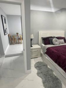 a white bedroom with a bed and a room with a table at Villa Sosa in Fort Myers